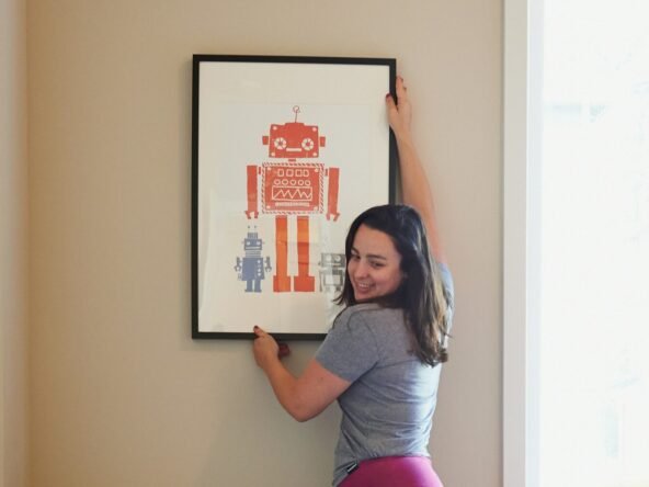 woman in gray shirt and pink pants sitting on gray chair